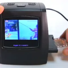 Un escáner de película digital muestra una imagen de un pescador. Se está introduciendo una tira de negativo en el dispositivo, mostrando cómo escanear negativos.