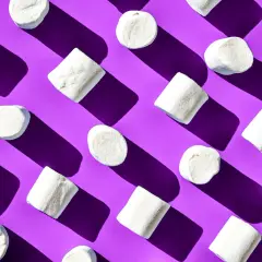 Malvaviscos blancos dispuestos en patrón diagonal sobre fondo morado, un ejemplo visual de la ley de pregnancia o buena forma.