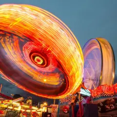 Luces de feria girando en un espectáculo de long exposure photography.