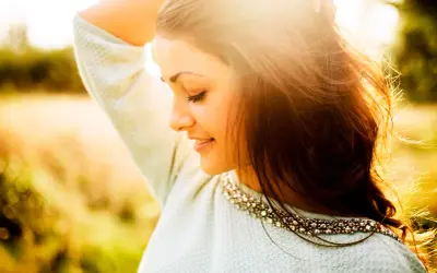Momentos capturados en estas fotos pilladas: una joven sonríe con el sol en su rostro, su cabello suelto y un suéter adornado.