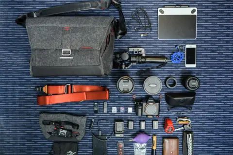 Un ejemplo de **knolling**: equipo fotográfico y de video organizado meticulosamente: cámara, lentes, estabilizador, tablet gráfica, teléfono, accesorios y bolso.