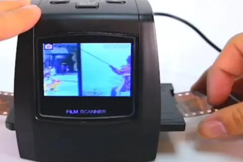 Un escáner de película digital muestra una imagen de un pescador. Se está introduciendo una tira de negativo en el dispositivo, mostrando cómo escanear negativos.