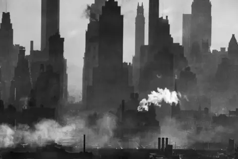 Silueta de rascacielos neoyorquinos envueltos en humo, capturada por Andreas Feininger.