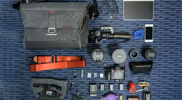 Un ejemplo de **knolling**: equipo fotográfico y de video organizado meticulosamente: cámara, lentes, estabilizador, tablet gráfica, teléfono, accesorios y bolso.