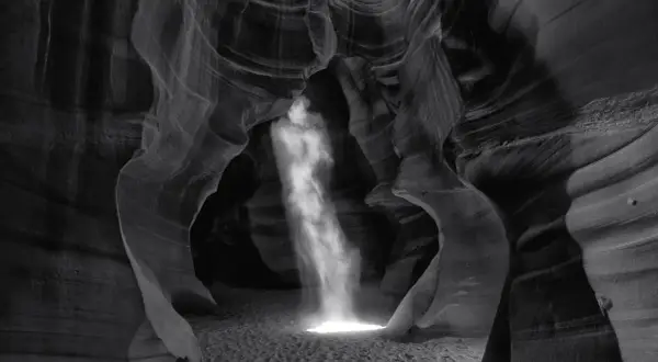 Columna de luz ilumina cañón de arena, creando una escena etérea. Esta podría ser la **fotografía más cara del mundo** por su belleza única.