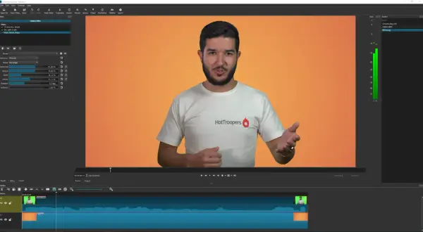 Un hombre con camiseta blanca habla frente a un fondo naranja. El software de edición de video muestra un efecto de croma que es, eliminando el fondo verde.