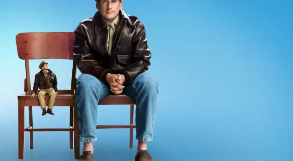 Mark Hogancamp, un hombre sentado en una silla, mira a su figura en miniatura en otra silla.
