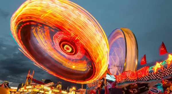 Luces de feria girando en un espectáculo de long exposure photography.