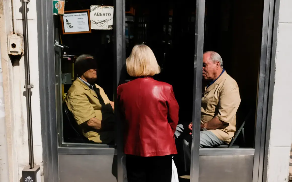 Una mujer de rojo observa a dos hombres dentro de una barbería. La composición sigue la regla de los tercios, creando una escena intrigante.
