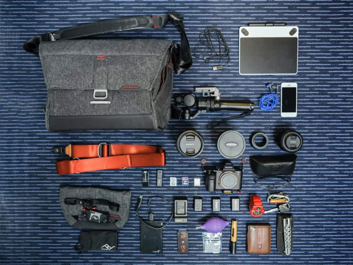 Un ejemplo de **knolling**: equipo fotográfico y de video organizado meticulosamente: cámara, lentes, estabilizador, tablet gráfica, teléfono, accesorios y bolso.