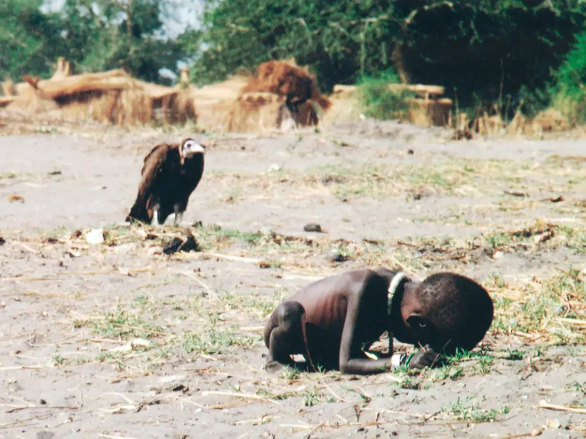 Un niño desnutrido y un buitre en un paisaje árido. Una imagen impactante que podría ser parte de fotos premiadas.