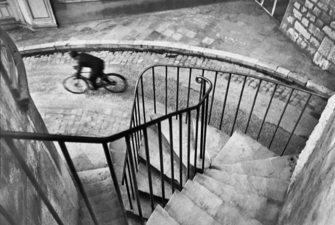 Ciclista en movimiento capturado por uno de los grandes fotógrafos del mundo. La imagen evoca la velocidad y el dinamismo.