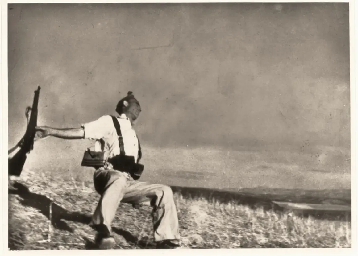Soldado con rifle en mano, capturado en un momento dramático que evoca la muerte de Gerda Taro.