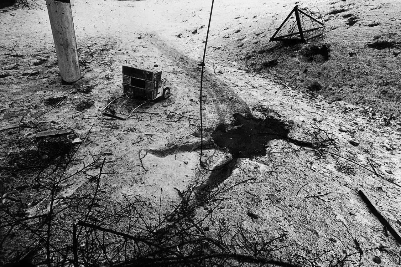 Un generador abandonado y un alambre en un paisaje desolado, capturado por Stanley Greene.