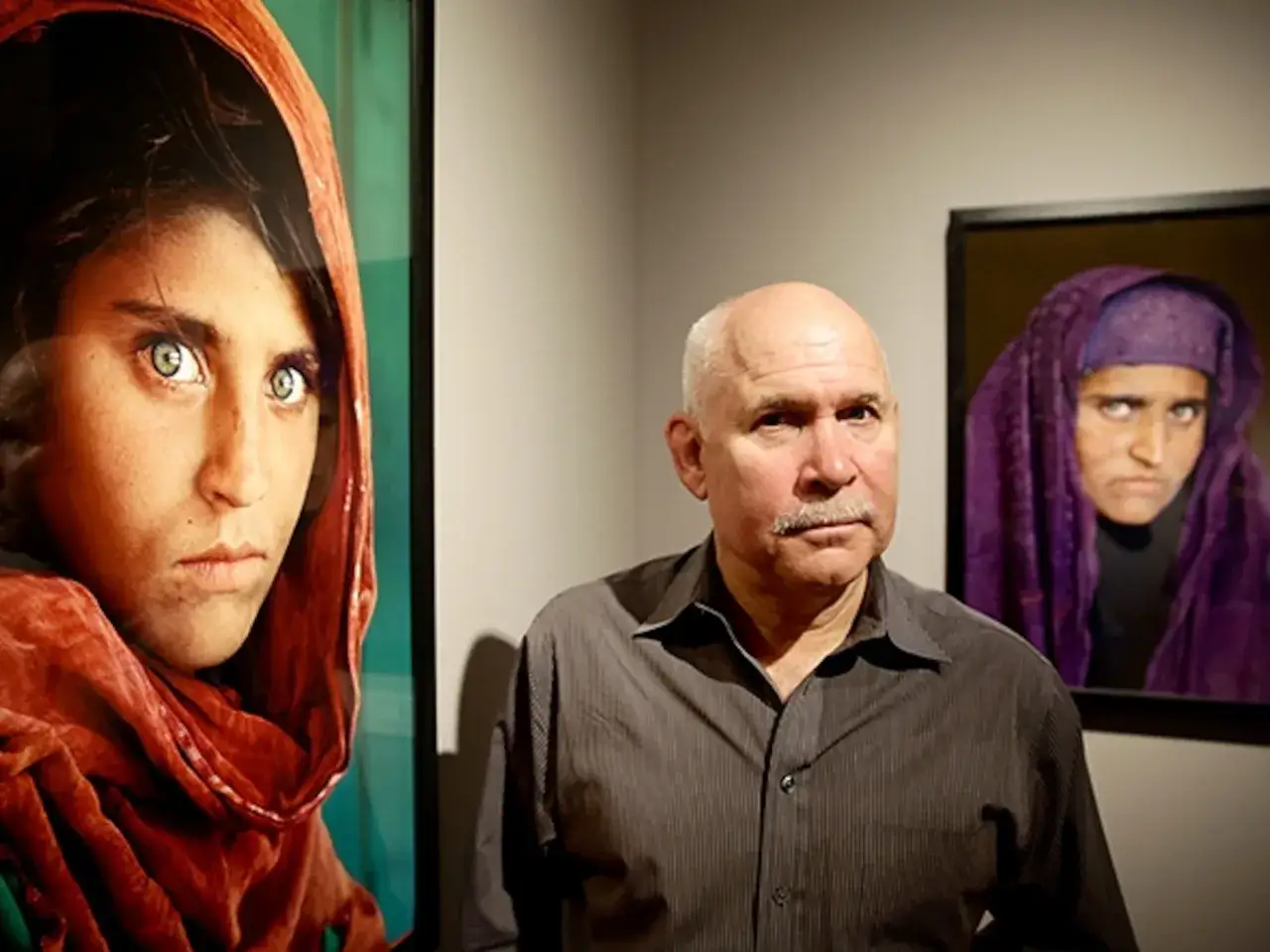 Steve McCurry, autor de ic&oacute;nicas fotos, posa junto a retratos de mujeres afganas.