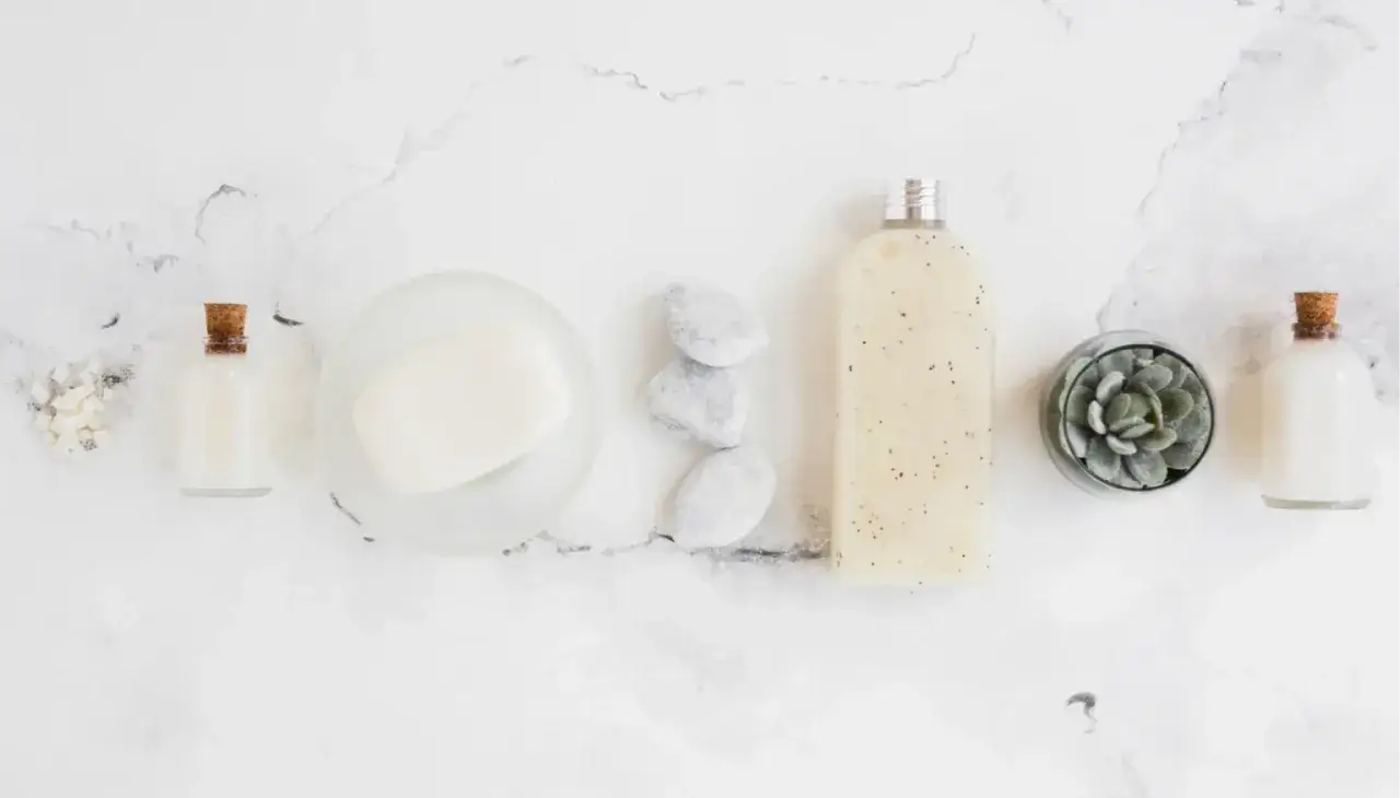 Productos de spa con un jab&oacute;n, botellas y una planta, listos para poner fondo blanco a una foto.