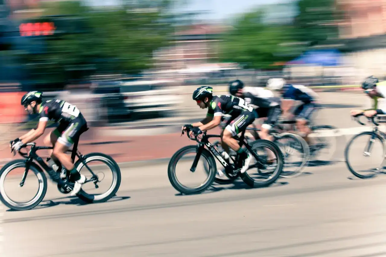 Ciclistas en carrera, capturados con un barrido fotográfico que resalta la velocidad y el movimiento.
