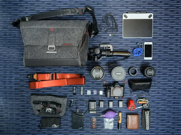 Un ejemplo de **knolling**: equipo fotográfico y de video organizado meticulosamente: cámara, lentes, estabilizador, tablet gráfica, teléfono, accesorios y bolso.