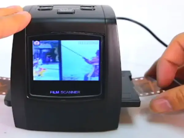 Un escáner de película digital muestra una imagen de un pescador. Se está introduciendo una tira de negativo en el dispositivo, mostrando cómo escanear negativos.