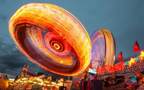 Luces de feria girando en un espectáculo de long exposure photography.