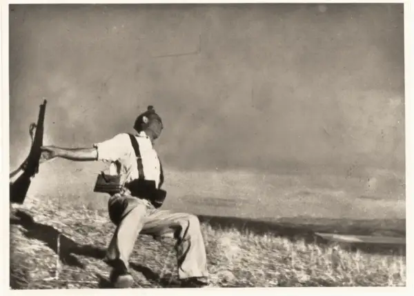 Soldado con rifle en mano, capturado en un momento dramático que evoca la muerte de Gerda Taro.